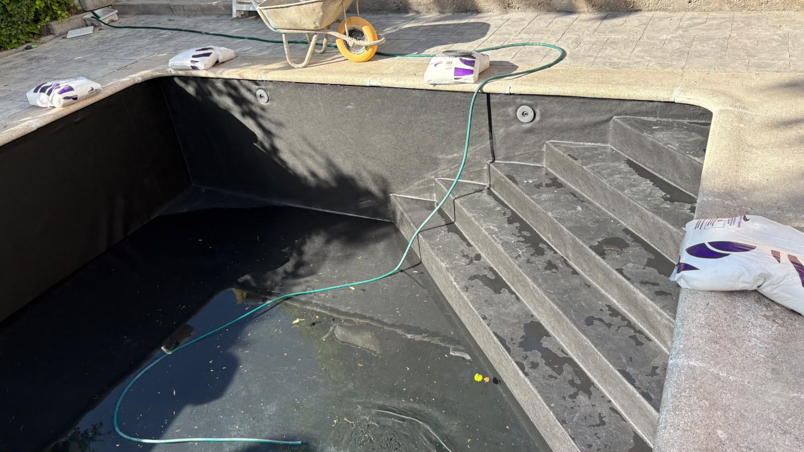 Escalera y paramentos de una piscina durante la impermeabilización